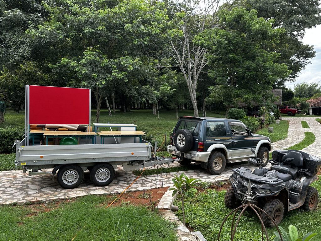 Ein Mann säubert Stühle vor einem Haus im Freien.
